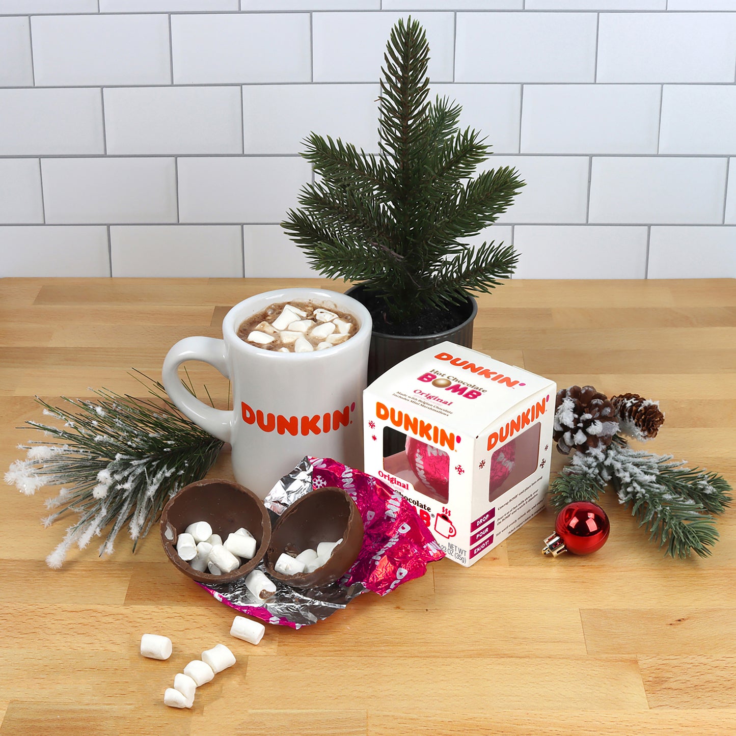 Dunkin' branded mug with hot chocolate, chocolate eggs, and packaging on a wooden table with festive decorations.