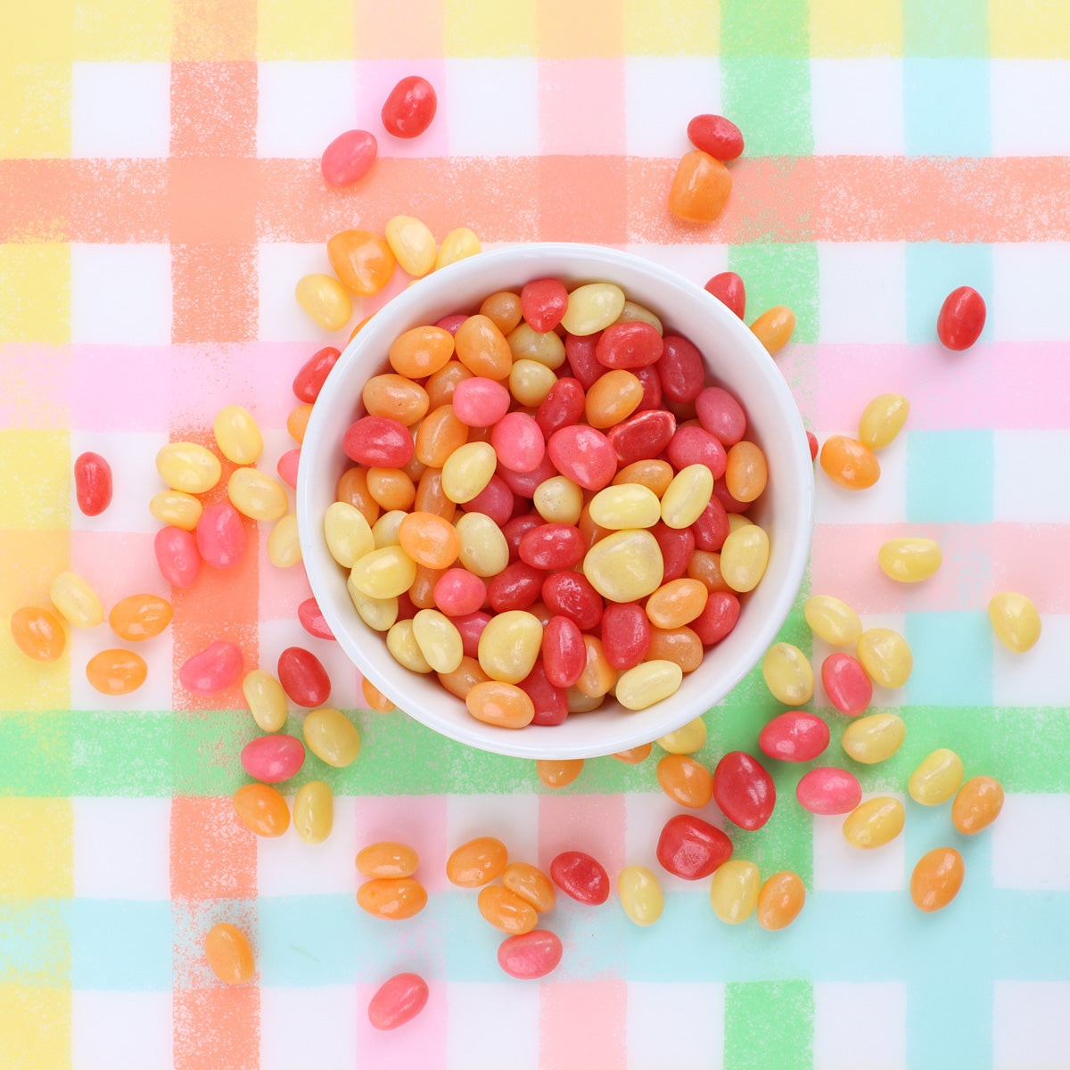 Loose dunkin' jelly beans in a bowl with loose jelly beans surrounding it