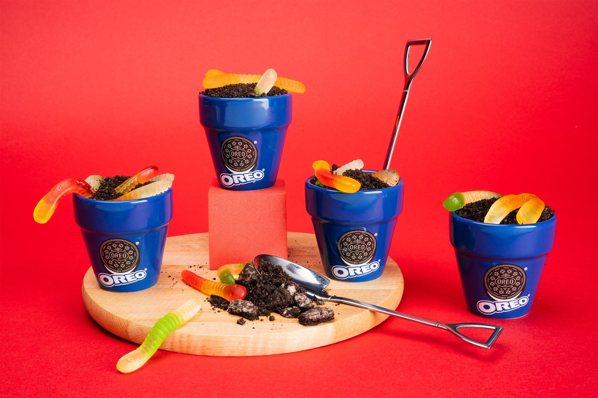 OREO cookie pots with gummy worms on a red background