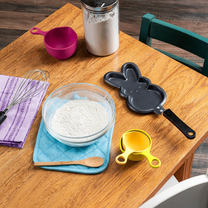 Single peeps skillet next to pancake mix and mixing utensils 