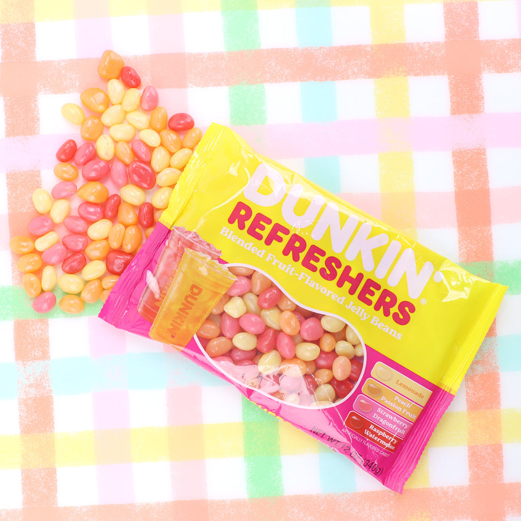 Opened dunkin' refreshers bag with jellybeans spilling out onto tablecloth 