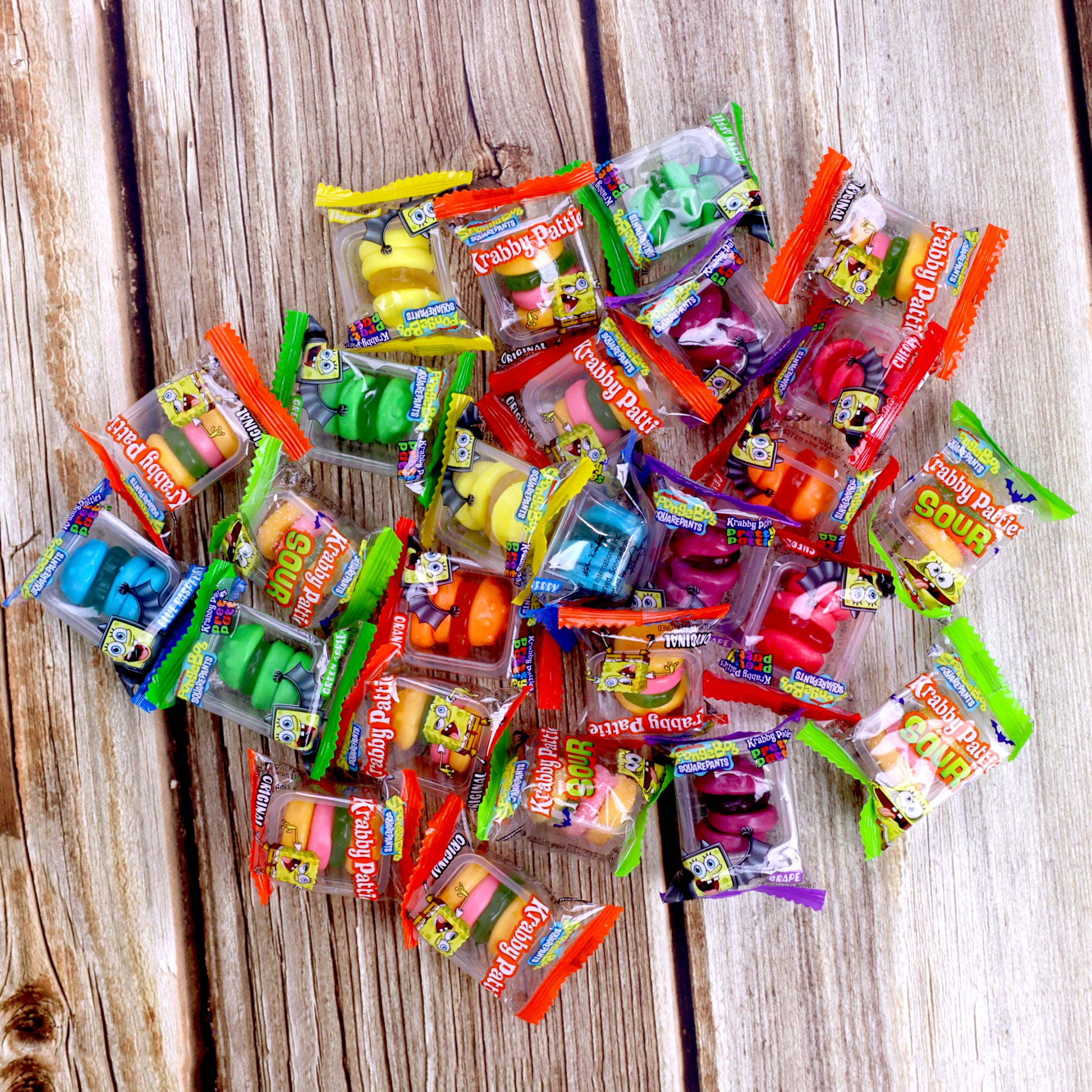 Assorted colorful gummy candy packages on a wooden surface