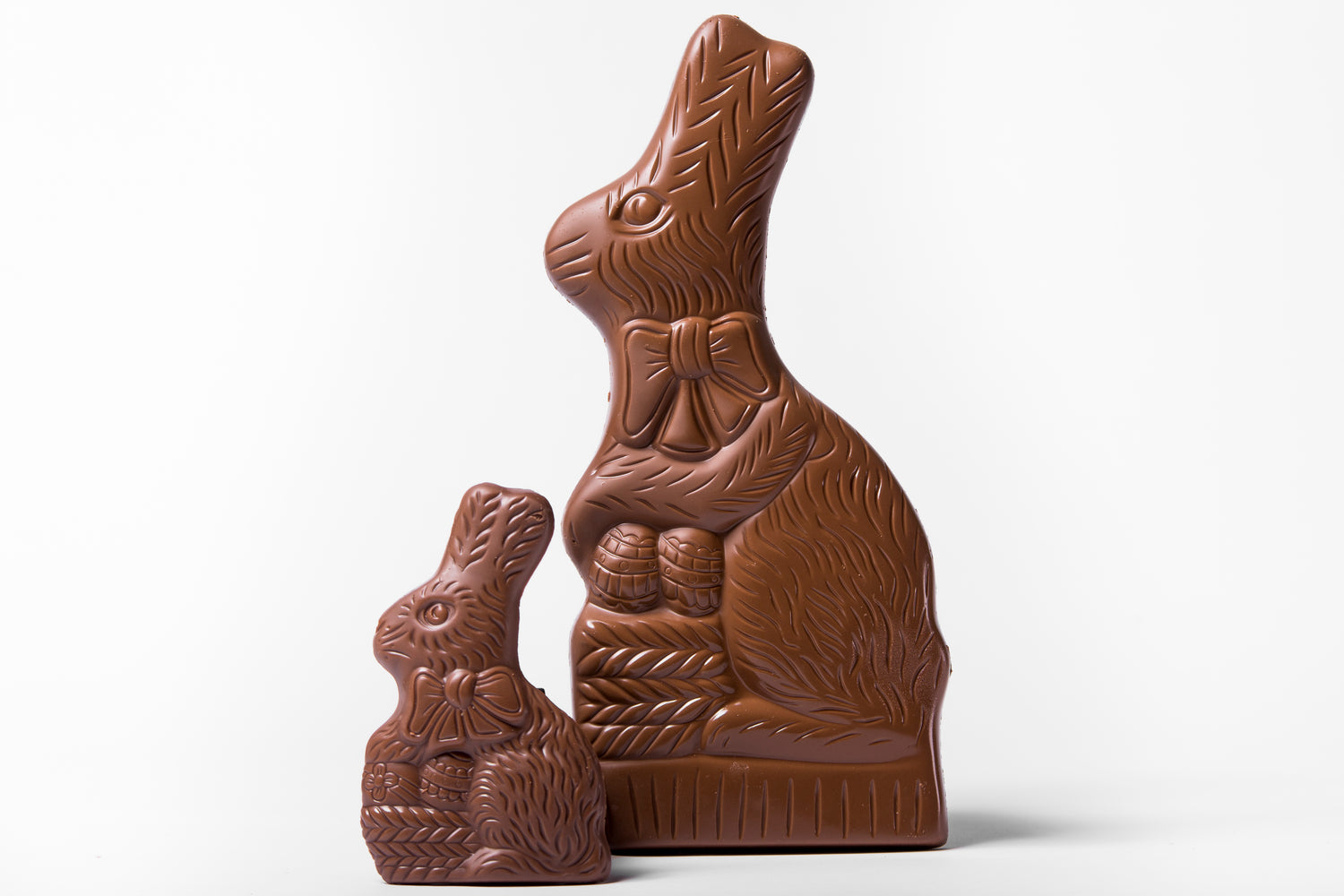 large and small chocolate bunnies over white background