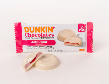 white and pink wrapper with 2 Dunkin Jelly Donut chocolates inside. Two Dunkin Jelly Donut chocolates in front. 