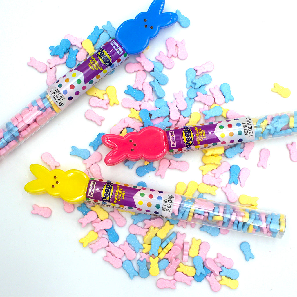 Clear tubes with colorful hard candies topped with multi colored bunnies and laying on pile of hard candies