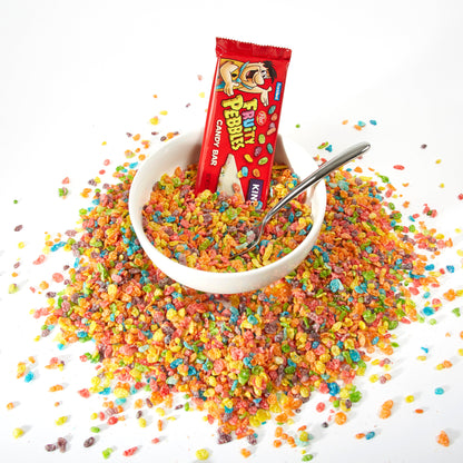 Red wrapped candy bar in bowl of fruity pebbles on top of pile of fruity pebbles cereal