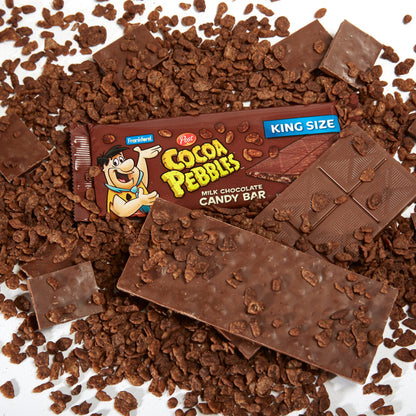 1 brown chocolate bar wrapper surrounded by loose cocoa pebbles and broken up chocolate bars
