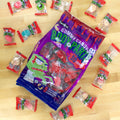 Purple bag with individually wrapped gummy body parts surrounding bag