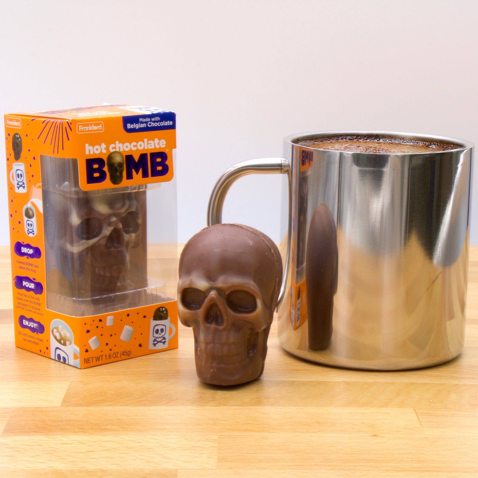 orange box with brown chocolate molded skull and silver mug of hot cocoa 