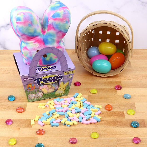 Purple Basket and tie dye plush gift set surrounded by colorful bunny candies and straw basket with plastic eggs